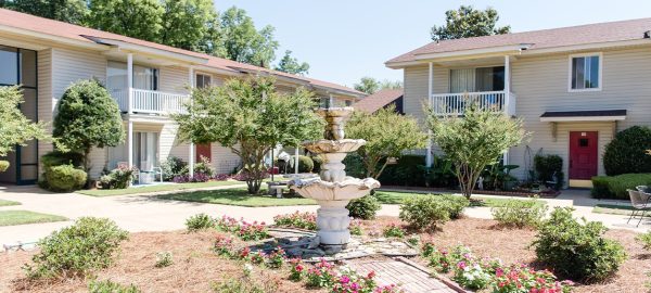 Beautiful Outdoor View Of A Property With A Decorative Fountain And Colorful Flowers, Representing Red Rock Realty Group's Residential Property Management Services.