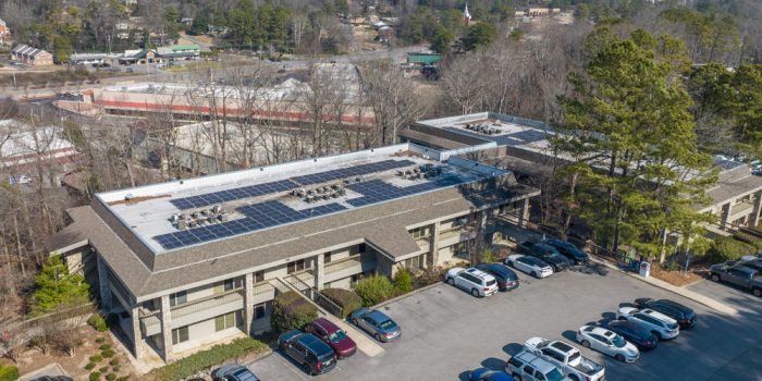Exterior View Of A Commercial Building Featuring A Few Signage, Surrounded By Parked Vehicles And Trees, Representing Available Commercial Real Estate Opportunities