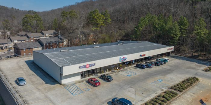 Exterior View Of A Commercial Building Featuring 'Select ABC Spirits' Signage, Surrounded By Parked Vehicles And A Wooded Area, Representing Available Commercial Real Estate Opportunities
