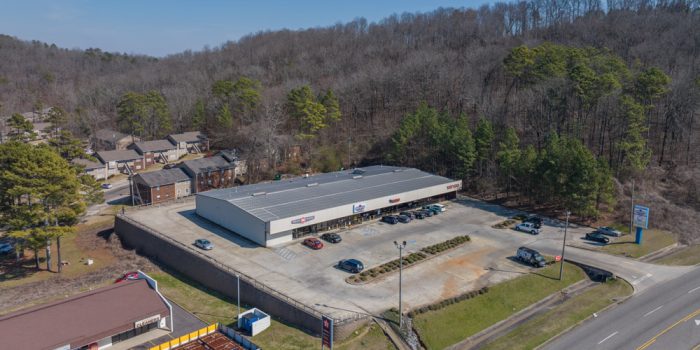 Exterior View Of A Commercial Building Featuring 'Select ABC Spirits' Signage, Surrounded By Parked Vehicles And A Wooded Area, Representing Available Commercial Real Estate Opportunities