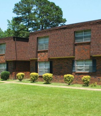 A Large Lawn In Front Of A Brick Building
