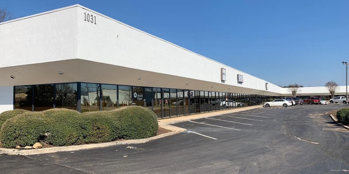 Exterior View Of A Commercial Building Featuring A Few Signage, Surrounded By Parked Vehicles, Representing Available Commercial Real Estate Opportunities