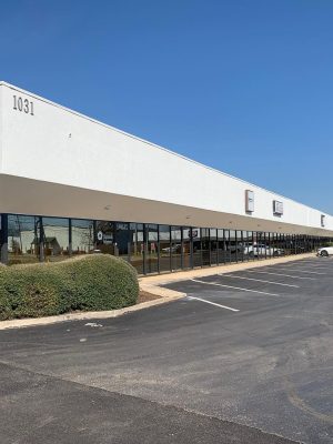 Exterior View Of A Commercial Building Featuring A Few Signage, Surrounded By Parked Vehicles, Representing Available Commercial Real Estate Opportunities