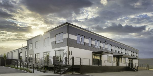 A Large Building With A Clock On The Side Of A Road