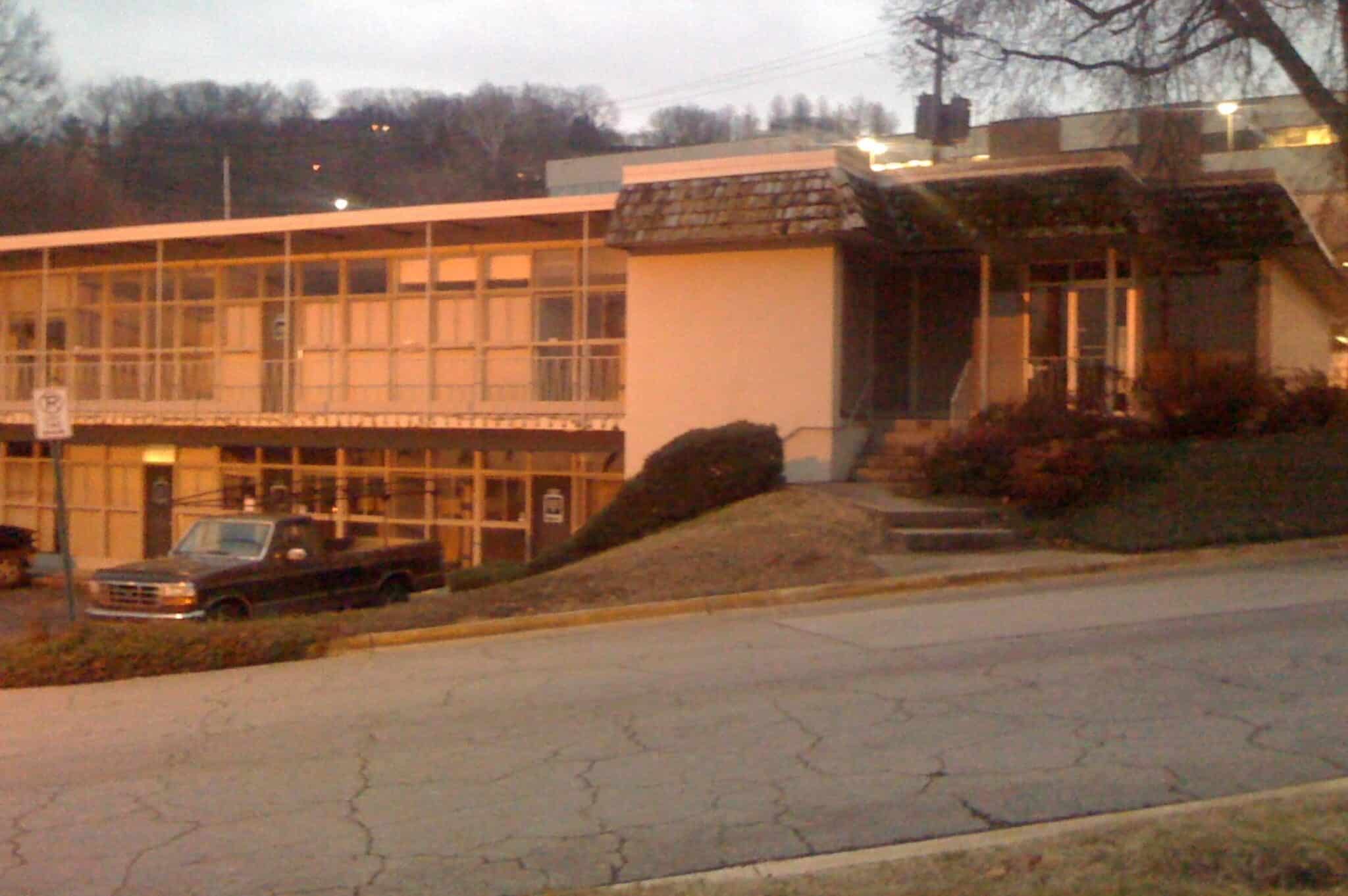 a building that has a sign on the side of a road