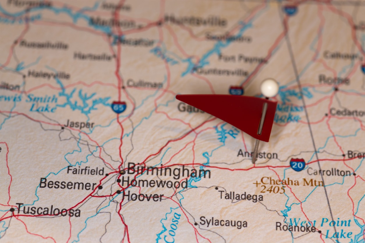 A close-up image of a map of Birmingham, AL, is shown with a flag push pin in a popular area for real estate development.